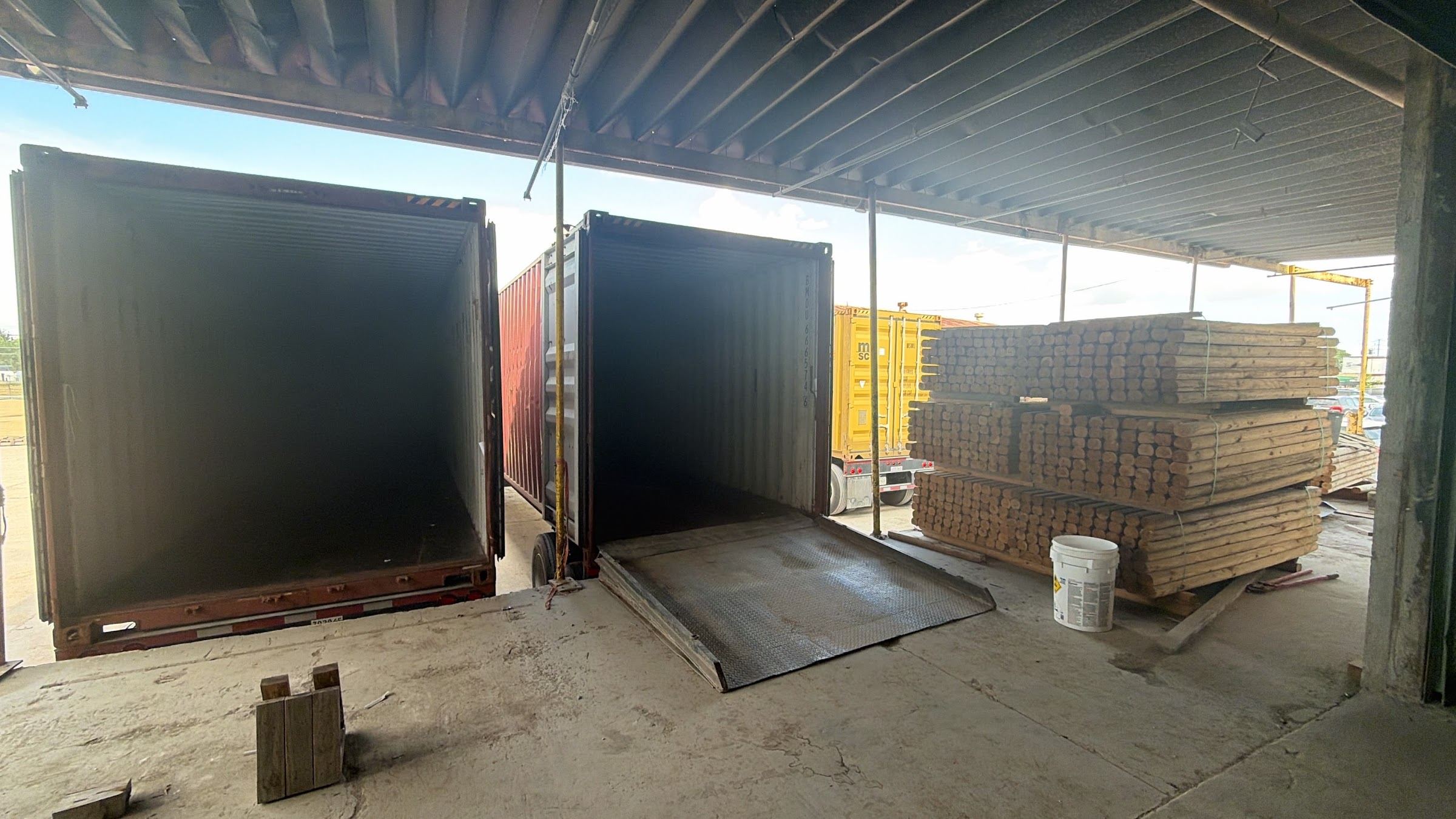 Two open shipping containers being loaded at the Ajeeb Overseas Houston facility